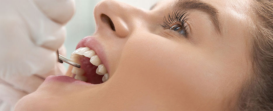 Stock Image of Model Checking her Teeth by Doctor